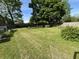 A large, open backyard features mature trees and a well-maintained lawn, perfect for outdoor activities at 8936 E 46Th St, Indianapolis, IN 46226