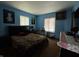This bedroom is painted blue with a queen bed and two windows at 8936 E 46Th St, Indianapolis, IN 46226