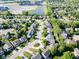 Aerial view showcases a residential neighborhood with winding streets and lush green trees at 9229 Crossing Dr, Fishers, IN 46037