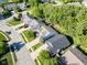 An aerial view showcases a quiet neighborhood with well-kept homes and verdant green spaces on a sunny day at 9229 Crossing Dr, Fishers, IN 46037