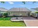 Backyard featuring a wood deck, firepit, green lawn, and mature landscaping, perfect for outdoor entertaining at 9229 Crossing Dr, Fishers, IN 46037