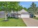 Charming single-story home with brick accents, attached garage, and well-maintained lawn and mature trees at 9229 Crossing Dr, Fishers, IN 46037