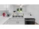 Bright kitchen with white countertops, stainless steel sink, and view of outdoor greenery through french doors at 9229 Crossing Dr, Fishers, IN 46037