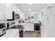 Bright kitchen featuring white cabinetry, modern appliances, and an open layout with view to living area at 9229 Crossing Dr, Fishers, IN 46037
