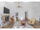 Open-concept living room with hardwood floors, a brick fireplace, and seamlessly connected to the adjacent kitchen area at 9229 Crossing Dr, Fishers, IN 46037