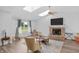 Bright and airy living room features hardwood floors, a cozy brick fireplace, and plenty of natural light through a large window at 9229 Crossing Dr, Fishers, IN 46037