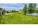 Expansive lawn overlooking a scenic lake, enhanced by a secure black chain-link fence at 994 Young'S Creek Dr, Franklin, IN 46131