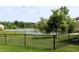 Large backyard with a black chain-link fence offers views of a peaceful lake at 994 Young'S Creek Dr, Franklin, IN 46131