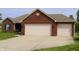 Brick home features an attached two-car garage with a well-maintained lawn at 994 Young'S Creek Dr, Franklin, IN 46131