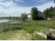 Expansive backyard view featuring lush greenery, a pond, and neighborhood homes at 10803 Gathering Dr, Indianapolis, IN 46259