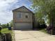 Two-story home featuring a two-car garage and well-maintained lawn with a long driveway at 10803 Gathering Dr, Indianapolis, IN 46259