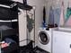 Functional laundry room with a washer, dryer, and storage shelves for organization at 10803 Gathering Dr, Indianapolis, IN 46259