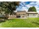 Well-maintained backyard with a spacious deck and the home's rear exterior under a partly cloudy sky at 1101 E Loretta Dr, Indianapolis, IN 46227