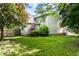 Landscaped backyard featuring a green lawn, mature trees, privacy fence, and home's exterior at 1101 E Loretta Dr, Indianapolis, IN 46227