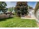 Expansive backyard showcasing a wooden deck, lush lawn, privacy fence, and mature trees at 1101 E Loretta Dr, Indianapolis, IN 46227