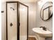 Updated bathroom with tiled shower, pedestal sink, modern bronze fixtures and wood look flooring at 1101 E Loretta Dr, Indianapolis, IN 46227