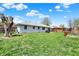 Spacious backyard with lush lawn, mature trees, play set, and white brick house at 1111 Cambridge Dr, Greenwood, IN 46142