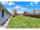 Wide backyard features a grassy lawn, wooden fence, and view of the back of the white brick house at 1111 Cambridge Dr, Greenwood, IN 46142