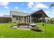 Backyard with a covered patio, picnic table, green lawn, and a fire pit area perfect for outdoor gatherings at 1124 Enchanted View Dr, Mooresville, IN 46158