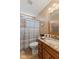 Traditional bathroom with a granite countertop, warm wood cabinetry, and a combined shower and tub at 1124 Enchanted View Dr, Mooresville, IN 46158