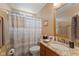 Cozy bathroom with a granite countertop vanity, decorative mirror, and a shower with a patterned curtain at 1124 Enchanted View Dr, Mooresville, IN 46158