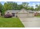 Charming brick home boasts a well-manicured lawn and attached three car garage at 1124 Enchanted View Dr, Mooresville, IN 46158
