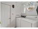 Well-lit laundry room with washer, dryer, storage cabinet, and convenient door access at 1124 Enchanted View Dr, Mooresville, IN 46158
