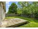 A backyard featuring a wood deck with a beautiful grassy area, surrounded by privacy fencing and large trees at 11821 Wapiti Way, Noblesville, IN 46060