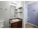 Bathroom vanity with white sink, black shelves, mirror, and access to a walk-in closet at 11821 Wapiti Way, Noblesville, IN 46060