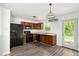 Well-lit eat-in kitchen with black appliances, laminate floors, and access to the backyard at 11821 Wapiti Way, Noblesville, IN 46060