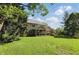 Expansive backyard view featuring a well-maintained lawn, a screened porch, and mature trees at 12335 Old Stone Dr, Indianapolis, IN 46236