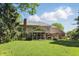 Expansive backyard featuring a well-maintained lawn, a screened porch, and mature trees at 12335 Old Stone Dr, Indianapolis, IN 46236