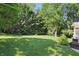 Lush backyard with green grass, mature trees, and an outdoor grill area at 12335 Old Stone Dr, Indianapolis, IN 46236
