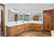 Spacious bathroom featuring double sink vanity with wooden cabinets, white countertop, and large mirrors at 12335 Old Stone Dr, Indianapolis, IN 46236