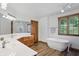 Beautiful bathroom features double sinks, soaking tub, wood look floors, and a wooden door at 12335 Old Stone Dr, Indianapolis, IN 46236