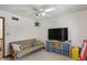 Bedroom features a ceiling fan, futon, shelving unit with bins, and a door to another room at 12335 Old Stone Dr, Indianapolis, IN 46236