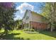 Lush green backyard view of tan colored home with brick accents and manicured landscaping at 12335 Old Stone Dr, Indianapolis, IN 46236