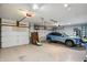 Spacious three-car garage with storage and a blue SUV parked inside at 12335 Old Stone Dr, Indianapolis, IN 46236