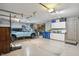 Spacious three-car garage with a blue SUV, storage cabinets, and overhead lighting at 12335 Old Stone Dr, Indianapolis, IN 46236
