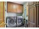 Efficient laundry room with front-load machines, cabinetry, and ample storage space at 12335 Old Stone Dr, Indianapolis, IN 46236