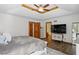 Spacious main bedroom featuring tray ceilings, ceiling fan, wood floors, and an entertainment center at 12335 Old Stone Dr, Indianapolis, IN 46236