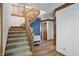 Carpeted staircase with wood trim and banister next to accent wall and wood-look floors at 12335 Old Stone Dr, Indianapolis, IN 46236
