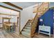 Staircase with wood trim with carpeted stairs adjacent to dining room and blue accent wall at 12335 Old Stone Dr, Indianapolis, IN 46236