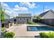 Backyard oasis featuring pool, outdoor kitchen with stone accents, and modern patio furniture at 1322 Marlowe Ave, Indianapolis, IN 46202