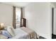 Comfortable bedroom with large window and neutral tones provides a relaxing space with soft lighting at 1333 Spann Ave, Indianapolis, IN 46203