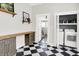 Well-lit laundry room featuring sleek checkerboard flooring, modern cabinets, and a washer/dryer unit in the closet at 1333 Spann Ave, Indianapolis, IN 46203