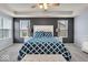 This primary bedroom boasts tray ceilings, two bedside tables, and a stylish blue and white bedspread at 13495 Forest Glade Dr, Fishers, IN 46037