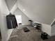 An attic space with bright lighting with a small treadmill, storage and coat rack at 1518 S Talbott St, Indianapolis, IN 46225