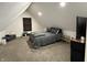 A cozy bedroom under a slanted roof, furnished with a full bed, side tables, and a small entertainment center at 1518 S Talbott St, Indianapolis, IN 46225