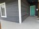 Inviting front porch featuring a bright teal door, modern railings, and a smooth, updated concrete floor at 1518 S Talbott St, Indianapolis, IN 46225